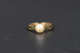 A cultured pearl solitaire ring, having pierced geometric style shoulders on a 9ct gold shank,