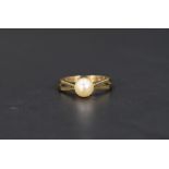 A cultured pearl solitaire ring, having pierced geometric style shoulders on a 9ct gold shank,