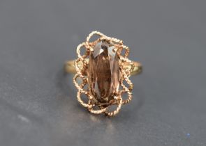 A smoky quartz dress ring, the oval cut smoky quartz set in a decorative twisted rope motif