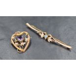 A 9ct gold openwork heart shaped brooch, having a central heart shaped amethyst surrounded by a vine