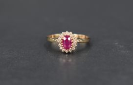 A ruby and diamond cluster ring, the central oval cut ruby, approx 0.60ct, with a sixteen diamond