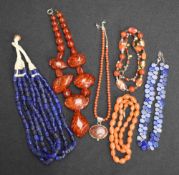 A selection of strings of beads including lapis lazuli, carnelian, Baltic amber style etc
