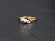 A diamond trilogy ring, approx 0.195ct total having twist shoulders to yellow metal loop, marks