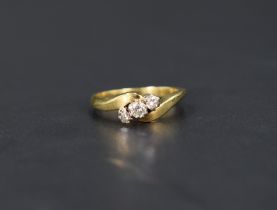 A diamond trilogy ring, the graduated diamonds with twist shoulders on an 18ct gold shank, ring size