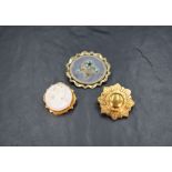 Three yellow metal brooches comprising a cameo depicting the Greek Goddess Selene in profile in a