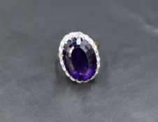 An amethyst and diamond oval cluster ring having large oval amethyst, approx 12ct surrounded by
