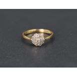 A diamond daisy cluster ring having a cushion mount on a yellow metal loop stamped 18ct, size K &