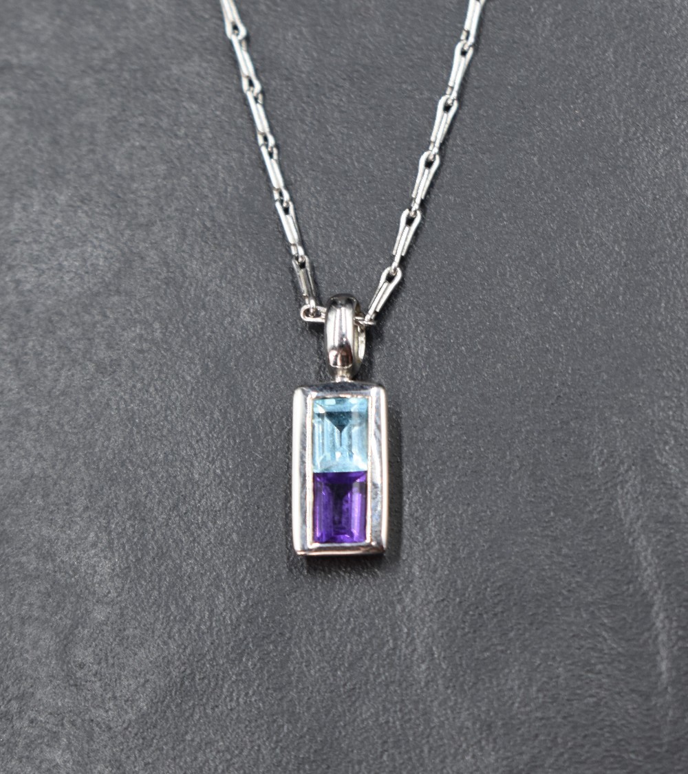 A 9ct white gold pendant having blue topaz and amethyst style stones in a rectangular mount on a 9ct