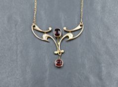 An Edwardian style pendant stamped 9ct having garnet decoration on a fixed chain, approx 17' & 5.2g