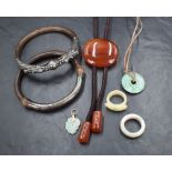 A small selection of costume jewellery including two Oriental silver and wood bangles, one having