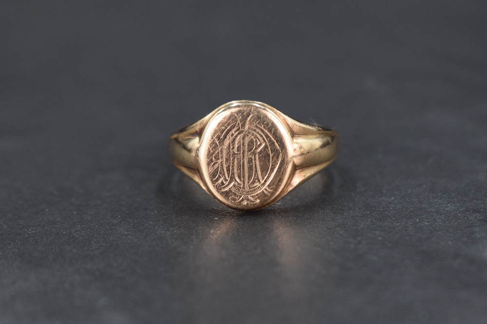 A 9ct gold signet ring, having a monogram engraved to the oval face with tapering shoulders, ring