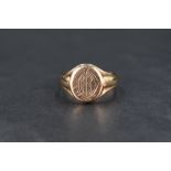 A 9ct gold signet ring, having a monogram engraved to the oval face with tapering shoulders, ring