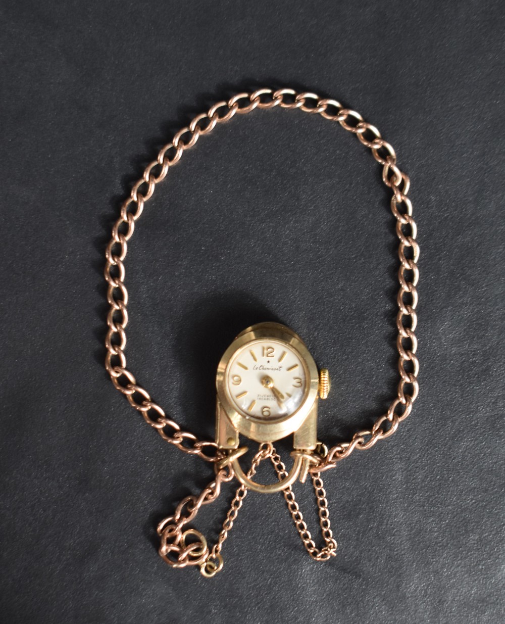 A 9ct rose gold curb link bracelet having a 9ct gold watch padlock clasp bearing name: Le