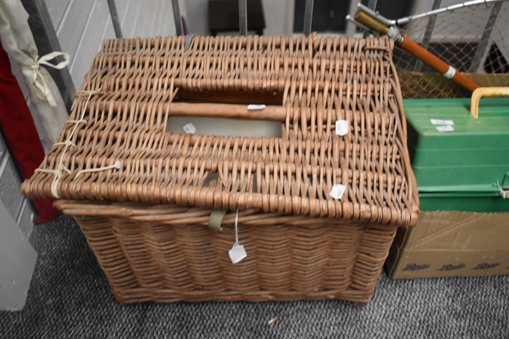 A wicker basket containing general fishing tackle including priest floats,hooks etc