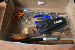 Four fishing priests and some tools including forceps crimpers , scissors and multi tool in a
