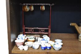 A selection of oriental ceramics,including tea bowls, and miniature cups, some of which are housed