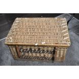 A large wicker laundry basket having Lakeland Laundries, Workington stencilled on back and front.