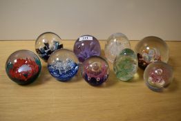Nine assorted glass paperweights including Caithness and Selkirk glass etc.