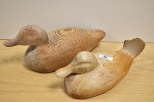Two 20th Century duck decoys, to include a yew wood decoy, the largest measures 30cm long