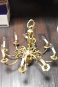 An large ornate brass chandelier having eight branches.