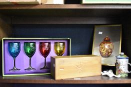 A group of four coloured glass goblets with etched Chinese design, a needlework embroidery depicting