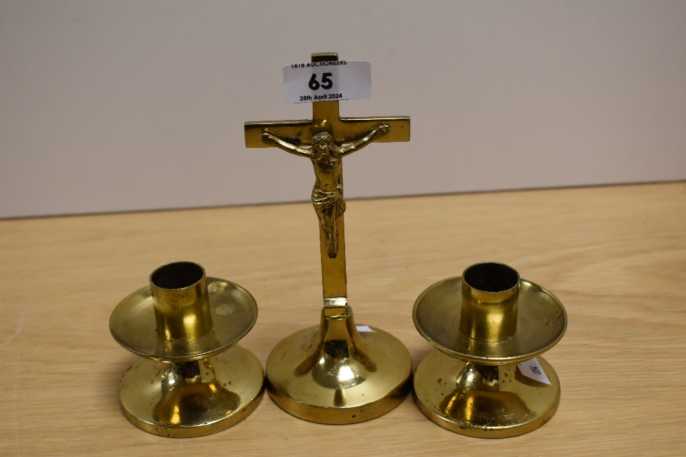 An early 20th Century brass altar set, comprising crucifix and two candles, the crucifix measures