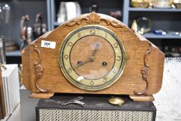An early 20th century oak mantel clock with pendulum and key.