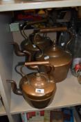 Two large copper kettles and a similar smaller one.