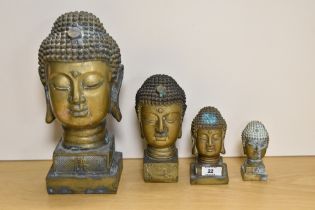 A group of four brass Buddha busts, of graduating sizes, the largest measures 32cm tall