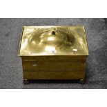 An Edwardian brass coal bin, having hinged lid, decorative banding design, and raised on four ball
