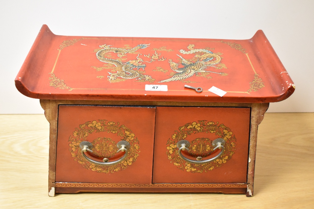 An early to mid-20th Century Chinese red lacquered cabinet, having two drawers, and measuring 33cm x