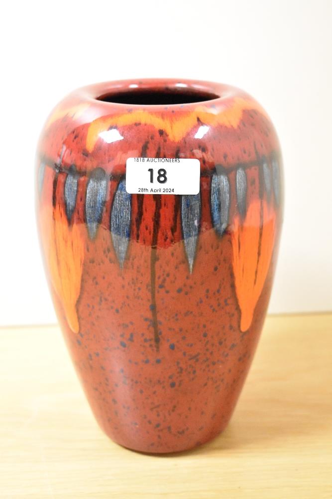 A vintage Poole Pottery vase, having red, orange and blue glaze.