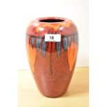 A vintage Poole Pottery vase, having red, orange and blue glaze.