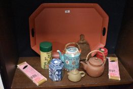 A large hexagonal painted metal tray and a collection of teapots, chopsticks and canisters.