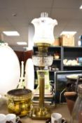 A brass oil lamp with corinthiun column base with cut glass reservoir and fluted etched shade and
