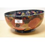 A Moorcroft Pottery fruit bowl, having tube lined grape and pomegranate design on cobalt blue