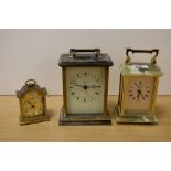 Two onyx and brass carriage clocks and a smaller similar alarm clock.