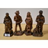 Four 20th Century continental wooden studies of figures with dogs, the largest measures 17cm tall