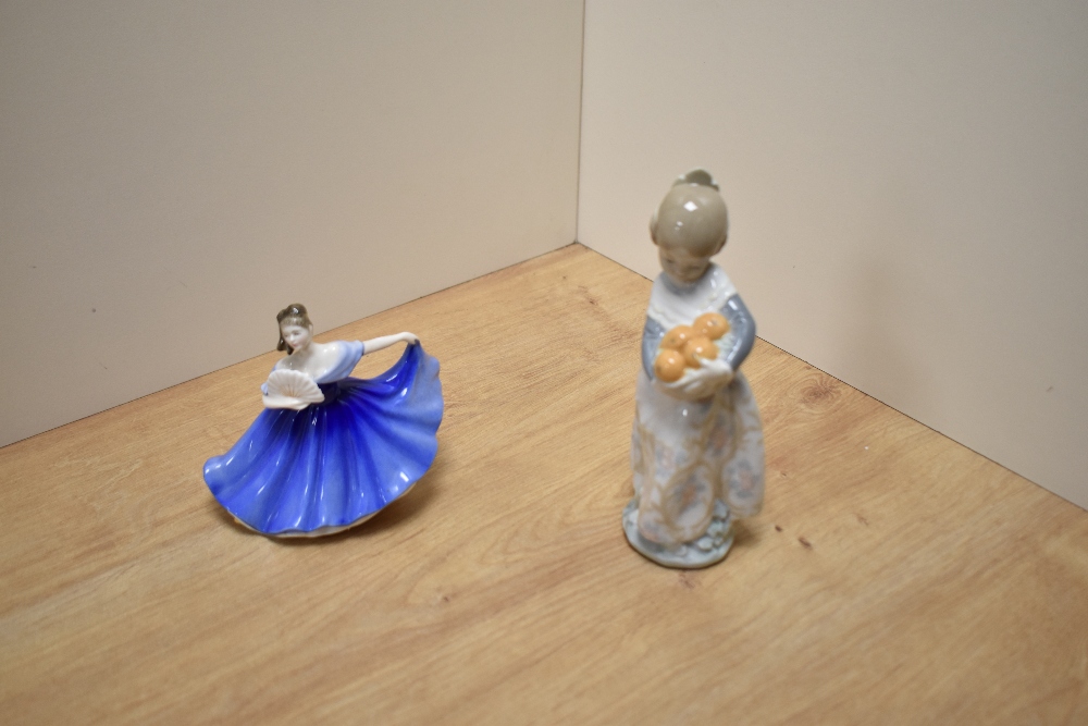 A Lladro porcelain figurine, Valencia girl with oranges, impressed number 4841, 16.5cm sold together