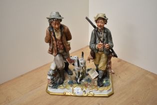 A CapoDiMonte Porcelain game hunting figure group, two hunters walking and their gun dog companion