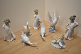 A group of eight Nao porcelain bird studies and figurines, three girls in nightdresses and white