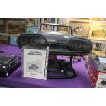 A Panasonic Bi Amp 4 Drive cd ' Ghetto Blaster ' on stand with remote and booklet - front of cd