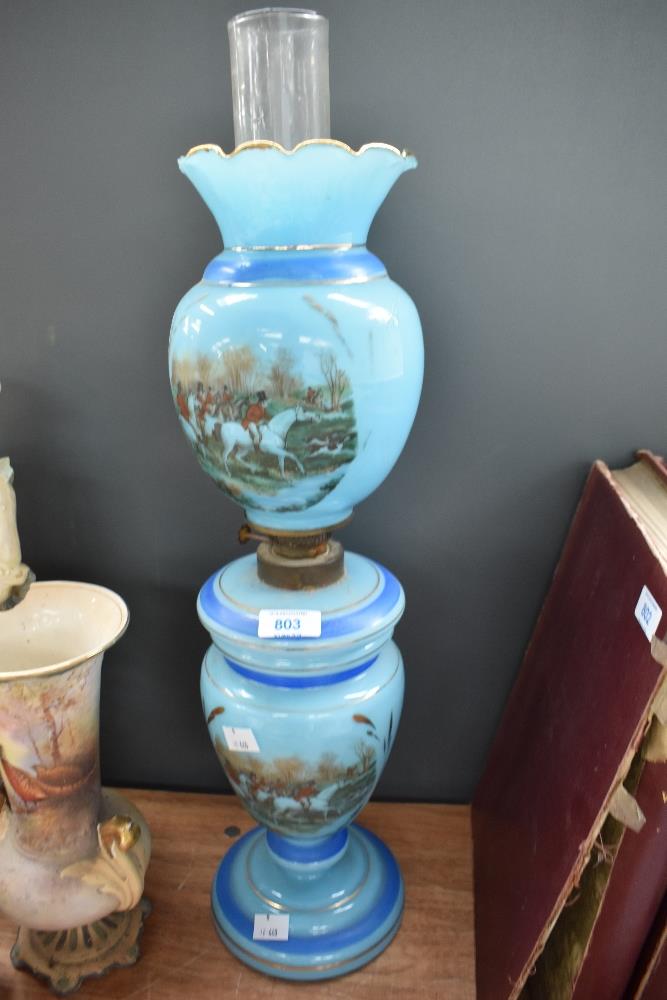 A Victorian blue opaline oil lamp having hunting pictoral decoration. Crack to top shade.