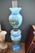 A Victorian blue opaline oil lamp having hunting pictoral decoration. Crack to top shade.