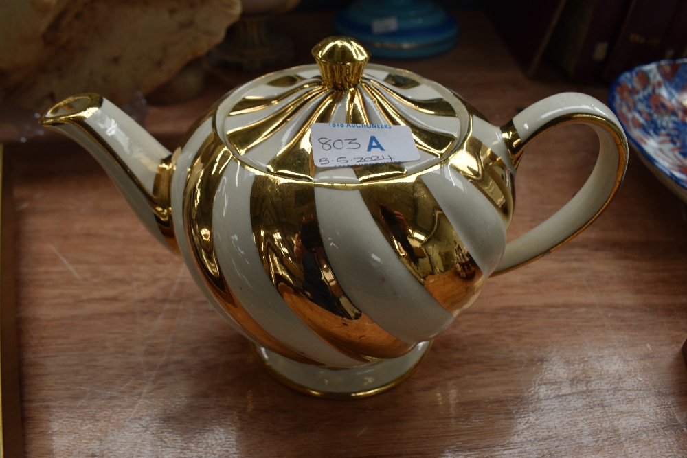 A cream and gold Sadler teapot.