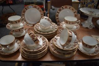 An assortment of breakfast cups and saucers and side plates, having white ground with dappled border