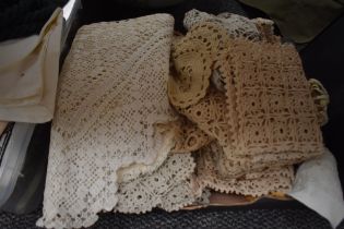 A carton of crocheted doilies and tray cloths and a crocheted four corner piece for fitting around a