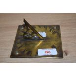 A novelty brass sun dial, in the form of a clock face with Roman numerals, etched date of 1709,