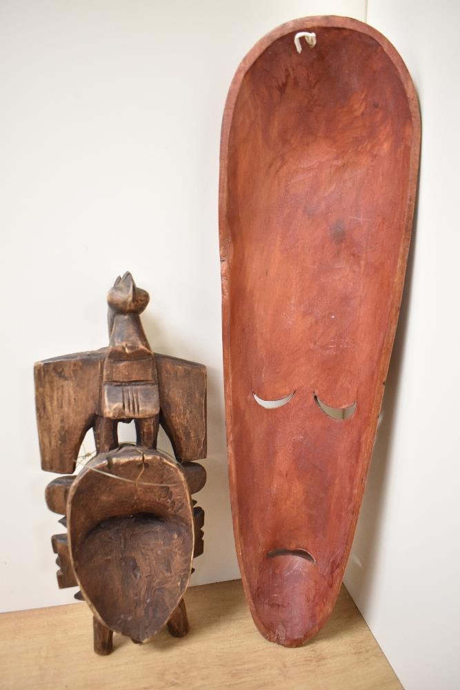 An Indonesian painted wooden tribal mask, of elongated form, measuring 48cm long, and another carved - Image 2 of 2