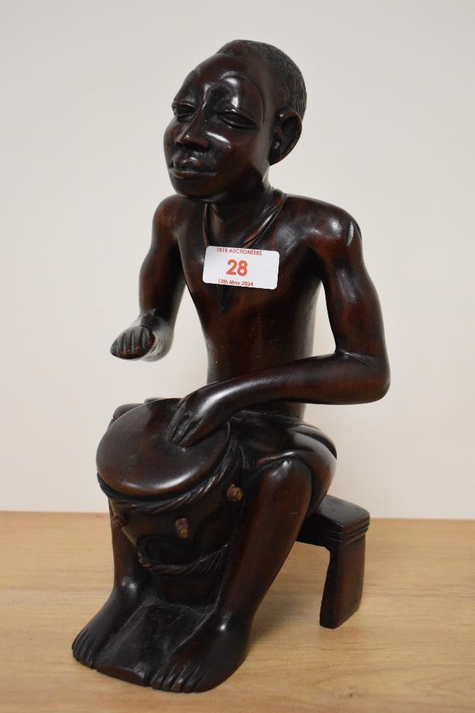 A 20th century African carved hardwood seated tribal drummer figure, approx 27cm.